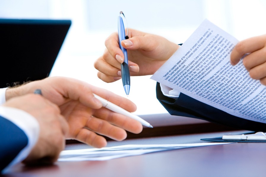 Accountancy professionals reviewing client documents for a CDD trigger-event review