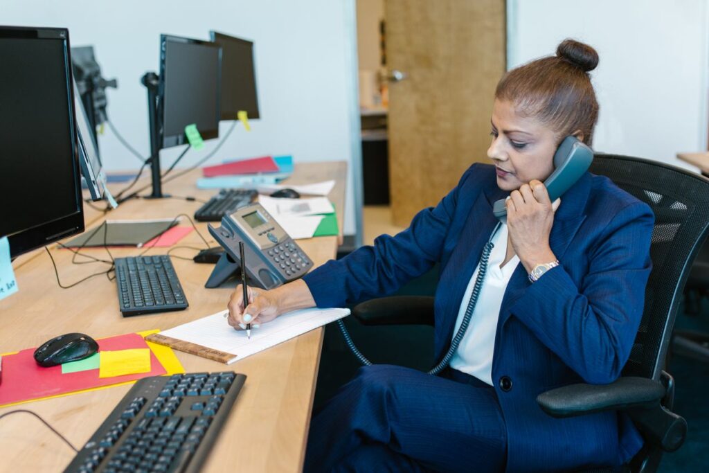 Accountancy professional reviewing notes during a client call as part of an AML compliance review.