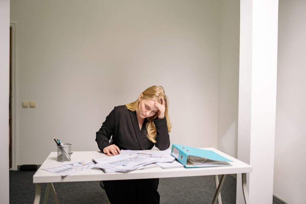 Sole practitioner accountant reviewing AML records and client files at a desk.