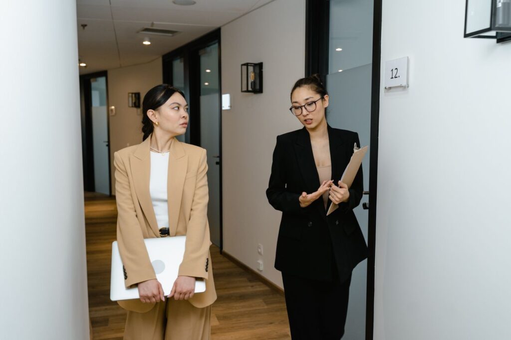 Two professionals discussing documents in an office, representing AML risk assessment and policy review in an accountancy firm.