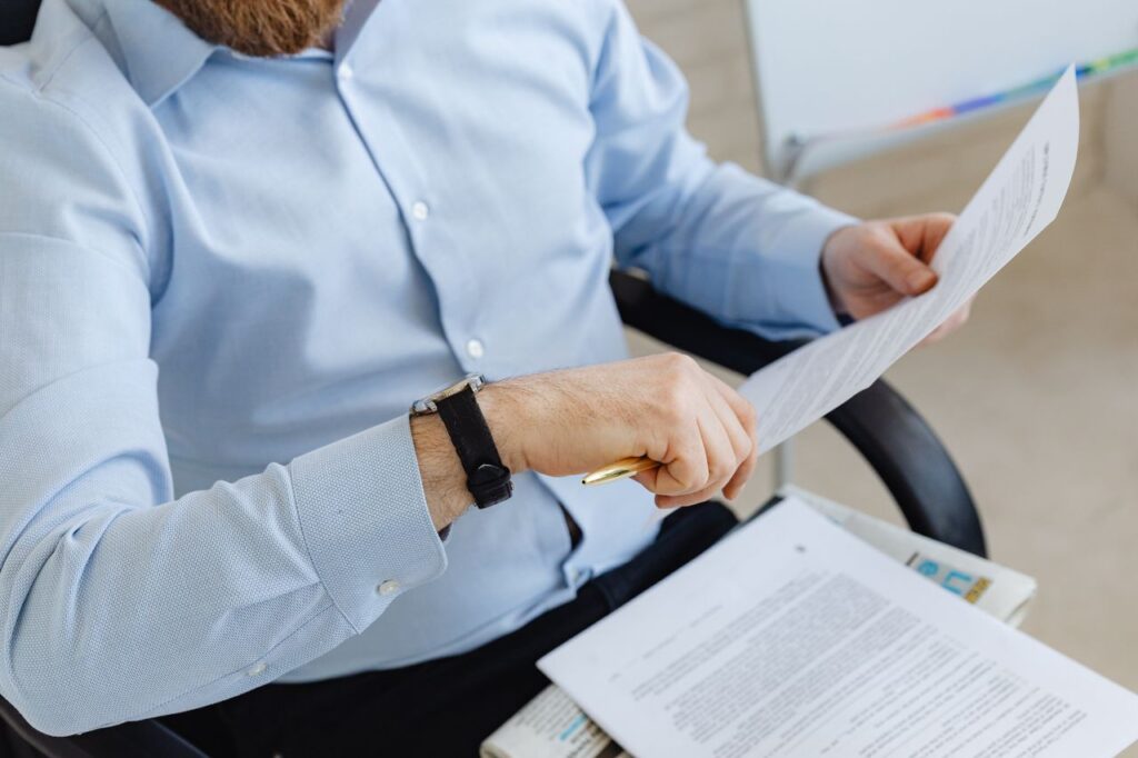 Accountant reviewing company documents for beneficial ownership checks before client acceptance.
