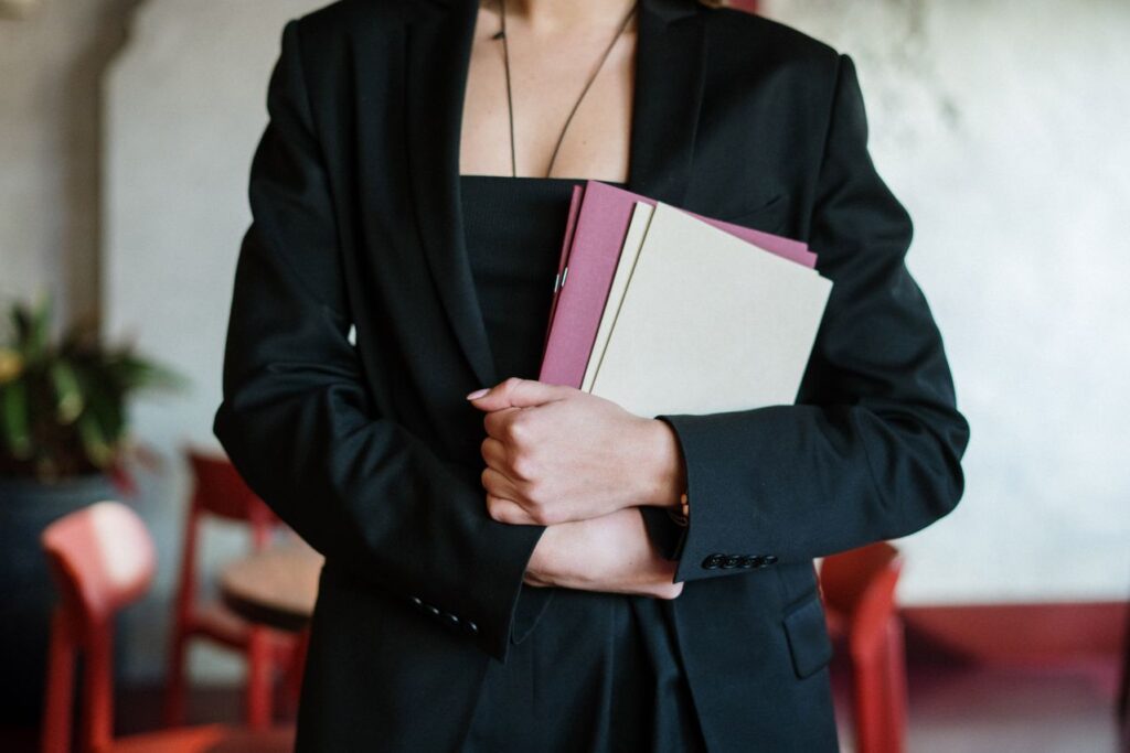 Professional holding folders and documents, representing complex ownership and control reviews for AML compliance in accountancy firms.