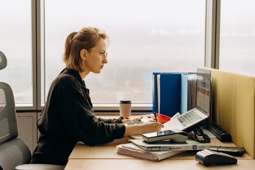 Professional reviewing accounting records at a desk, representing service-line AML risk assessment in an accountancy firm.