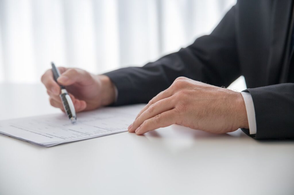 Person writing a PCP document at a desk